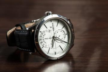 man's watch on wooden table