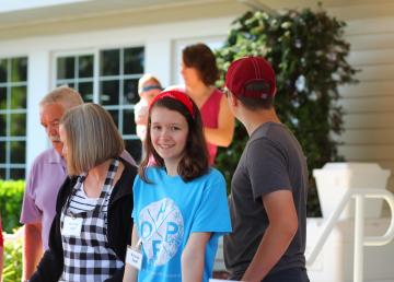 A young woman smiling while volunteering with a group