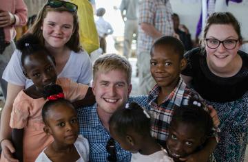 team members with church going kids in haiti